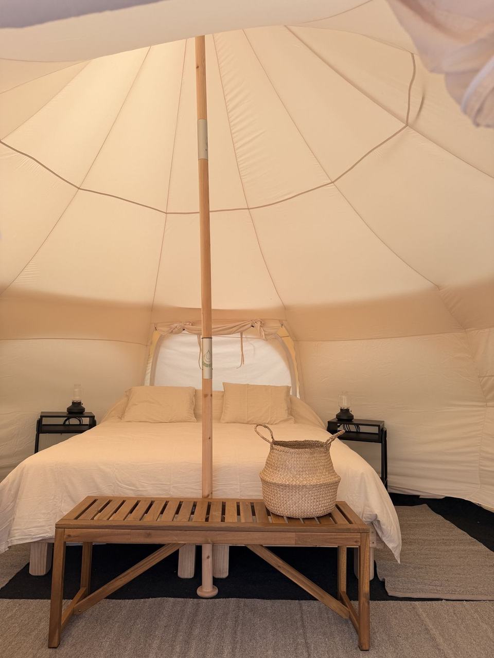 Interior de la carpa con cama king y veladores