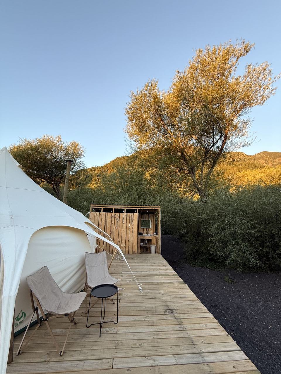Terraza de la carpa con sillas y vista a los cerros