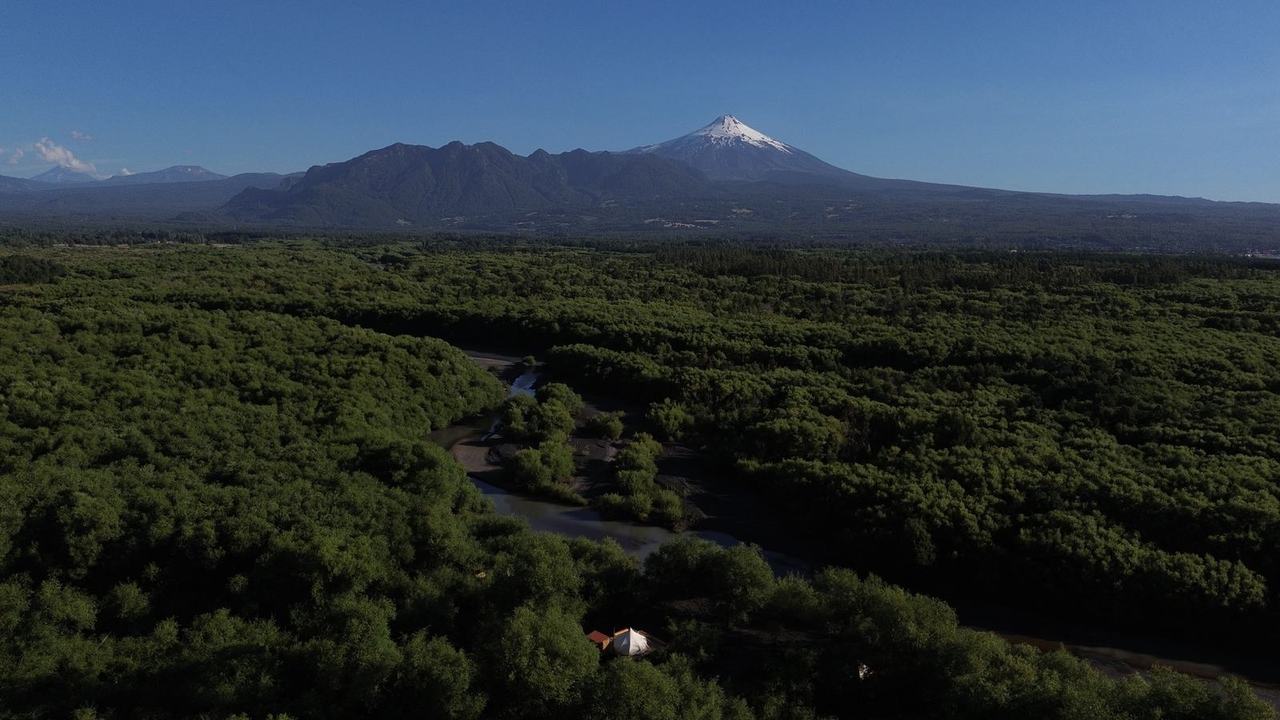 El glamping entre el bosque, con el volcán Villarrica al fondo