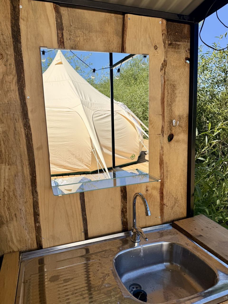 Lavamanos con espejo y vista a la carpa